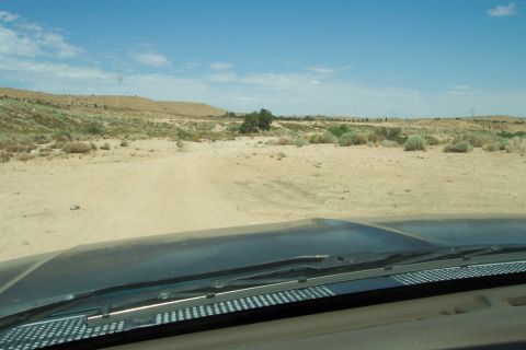 1995 Ford Bronco - Driving through a dry, arid landscape under a blue sky with scattered clouds.