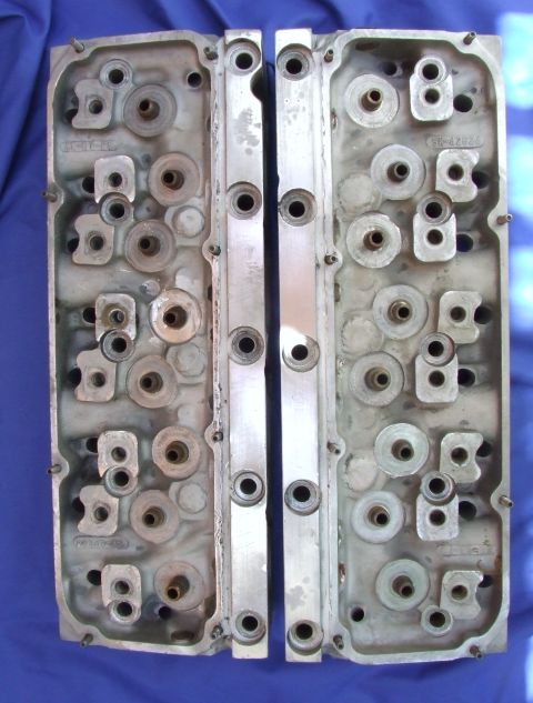 1973 Ford Mustang - Pair of aluminum engine cylinder heads shown on a blue surface.