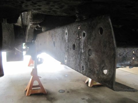 1979 Ford Bronco - The vehicle's frame is elevated on jack stands, revealing its undercarriage and suspension components.