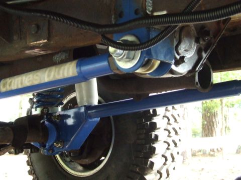 1976 Ford Bronco - Custom suspension components are installed on the vehicle, a visible tire and text on a blue bar.