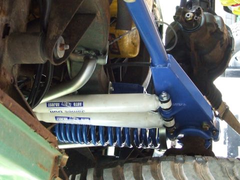 1976 Ford Bronco - Close-up view of modified suspension components, including shocks and springs, on an off-road vehicle.