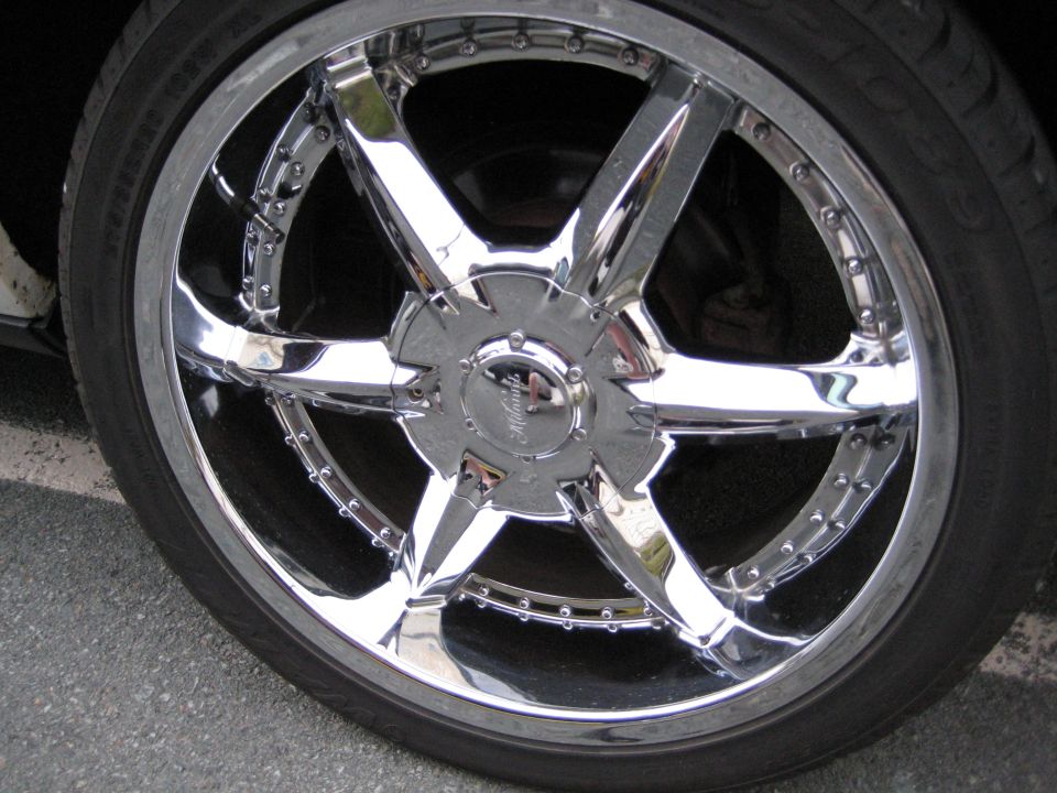 Close-up of chrome six-spoke aftermarket wheel with low-profile tire