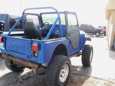 1978 Jeep CJ5 - A blue 1978 Jeep CJ5 is parked outdoors next to other vehicles.