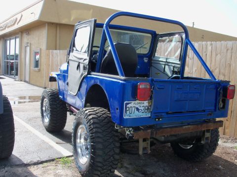 1978 Jeep CJ5 - Rear view of a lifted blue 1978 Jeep CJ5 with a roll cage and aftermarket bumper.