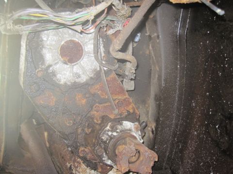 1979 Ford Bronco - This image shows a heavily rusted vehicle transmission and driveshaft, with exposed wiring above.