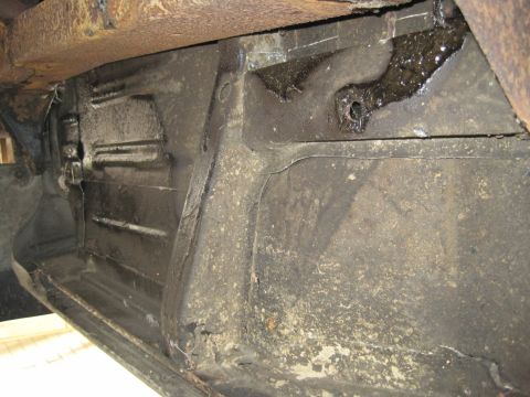 1979 Ford Bronco - Detail of the underbody and suspension components, showing signs of rust and oil leakage.