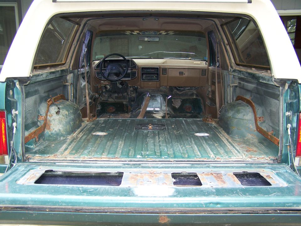 Green 1989 Ford Bronco interior and cargo area, viewed from rear with tailgate down