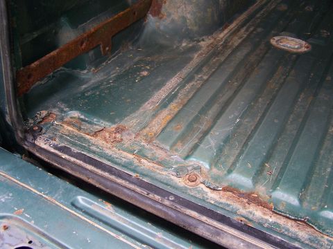 1989 Ford Bronco - The cargo area of this vehicle shows extensive rust and wear, particularly around the floor and seams.