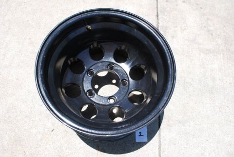 1996 Ford Bronco - A single black off-road wheel is shown against a concrete surface.