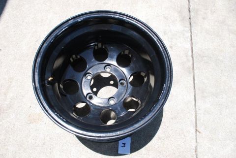 1996 Ford Bronco - A single black off-road wheel is shown against a concrete surface.