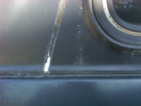1978 Ford Bronco - Close-up of a cracked dashboard interior, with visible text on the glass.