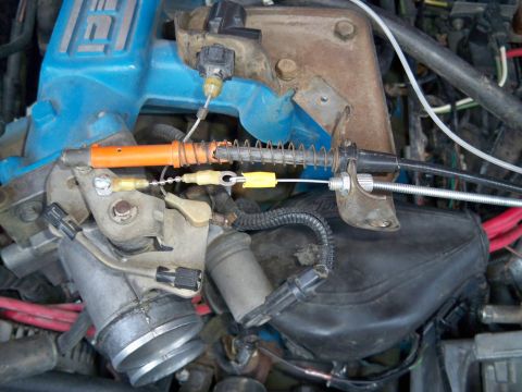 1985 Ford Bronco - Close-up view of engine throttle body and associated cables.