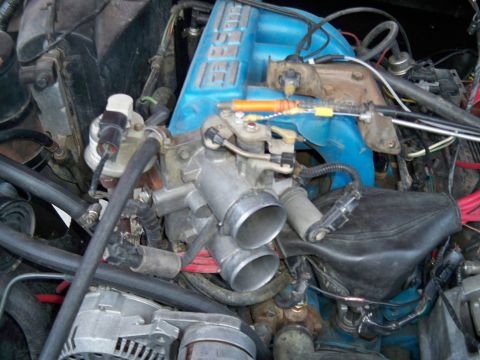 1985 Ford Bronco - A detailed view of the engine's intake system, showing the throttle body and manifold components.