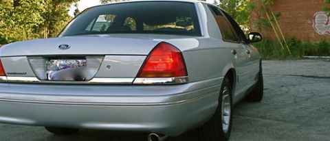 2000 Ford Crown Victoria - The rear of a silver Ford Crown Victoria is shown with a brick building in the background.