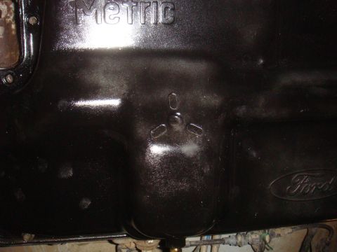 Black oil pan with embossed "Metric" and "Ford" logos
