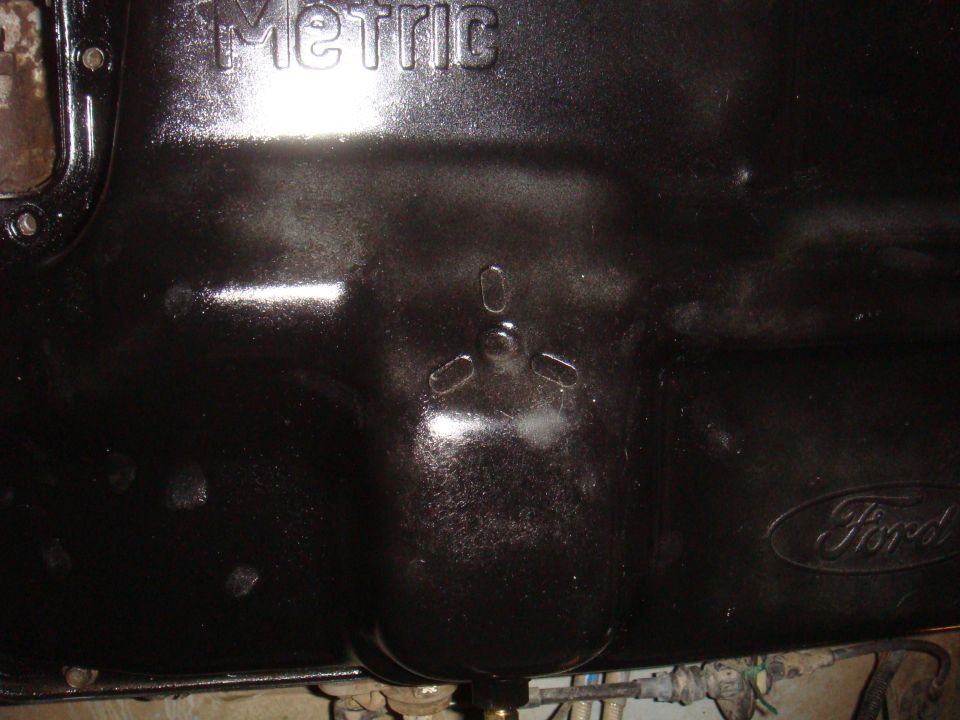 Black oil pan with embossed "Metric" and "Ford" logos