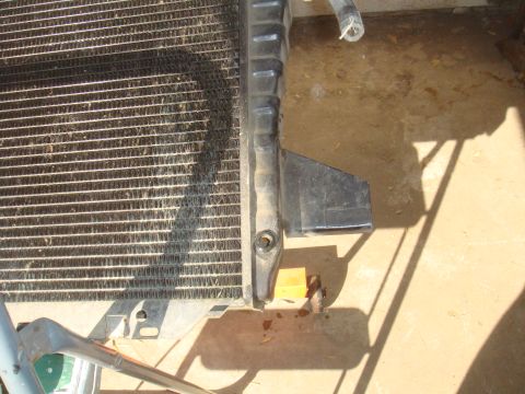 Radiator with black plastic shroud and metal brackets, on a concrete floor
