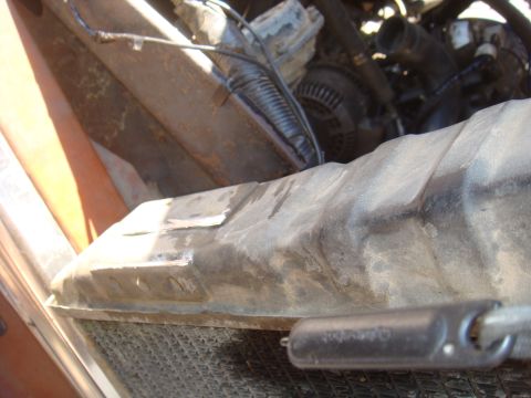 Close-up of a vehicle's radiator and engine bay components, with 'SUPERMOTORS' text visible