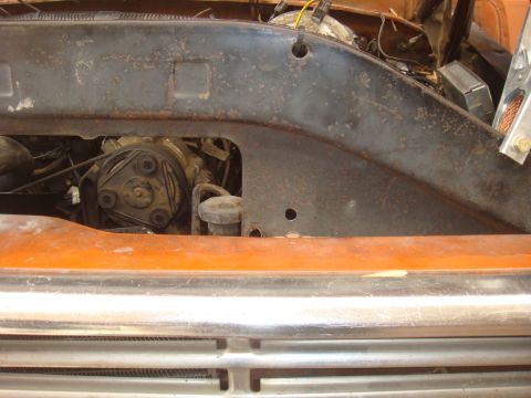 Engine bay view showing AC compressor and hoses. Orange fender visible