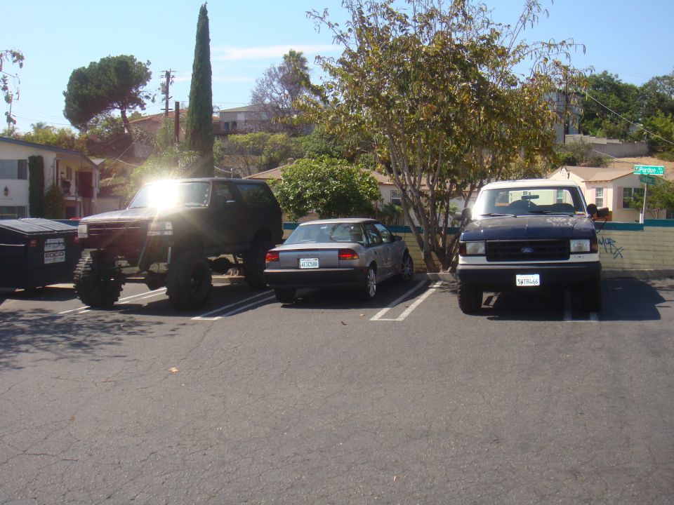 Lifted black 1992 Ford Bronco with large tires, parked in a lot