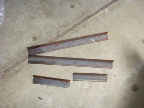 Four pieces of cut steel angle iron on a concrete floor