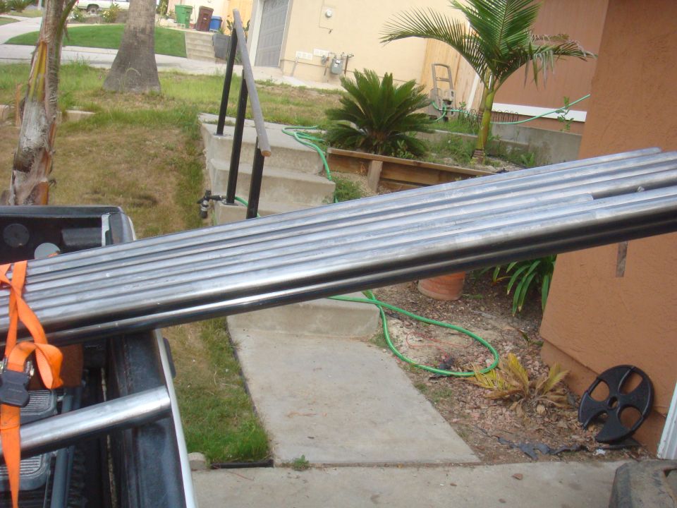Metal pipes loaded in truck bed with orange straps