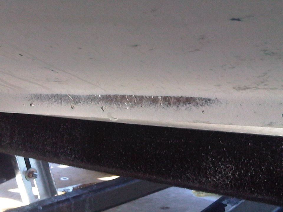 Close-up of a boat hull with some scuff marks and water droplets