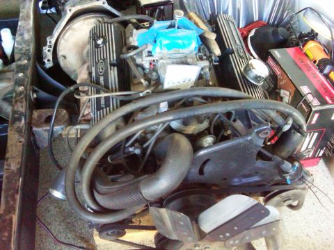 1986 Ford Bronco - Engine assembly with Ford Motorsport valve covers and carburetor, likely undergoing repair or modification.