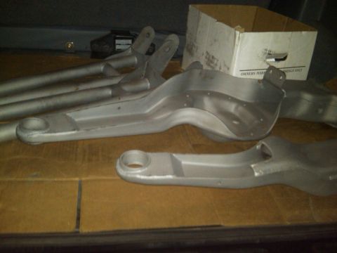 1986 Ford Bronco - Close-up of several suspension control arms, possibly for an off-road vehicle, resting on a cardboard surface.
