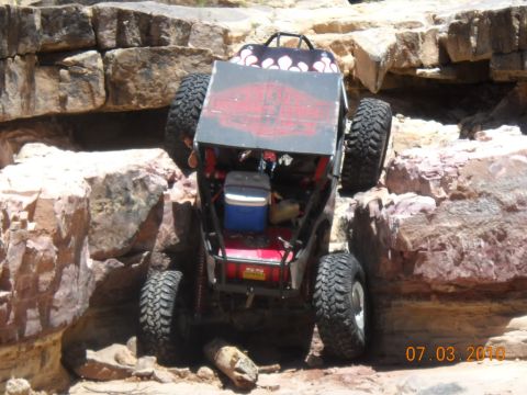 2009 Suzuki Samurai - Custom off-road buggy tackling a challenging rock climb on a sunny day.