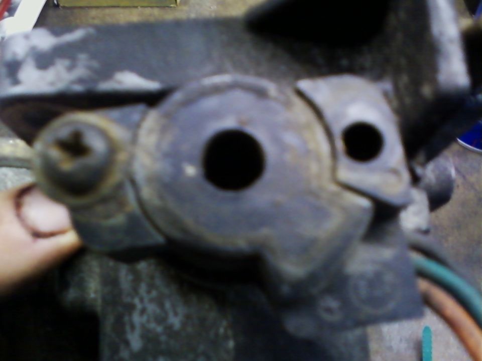 Close-up of a dirty cast aluminum throttle body showing the open throttle bore