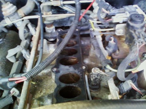 1990 Ford Bronco - Close-up view of an engine's intake manifold, showing ports and associated wiring.
