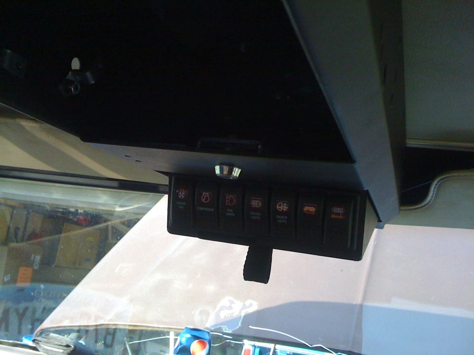 Overhead console with seven labeled rocker switches for fans, fog and driving lights