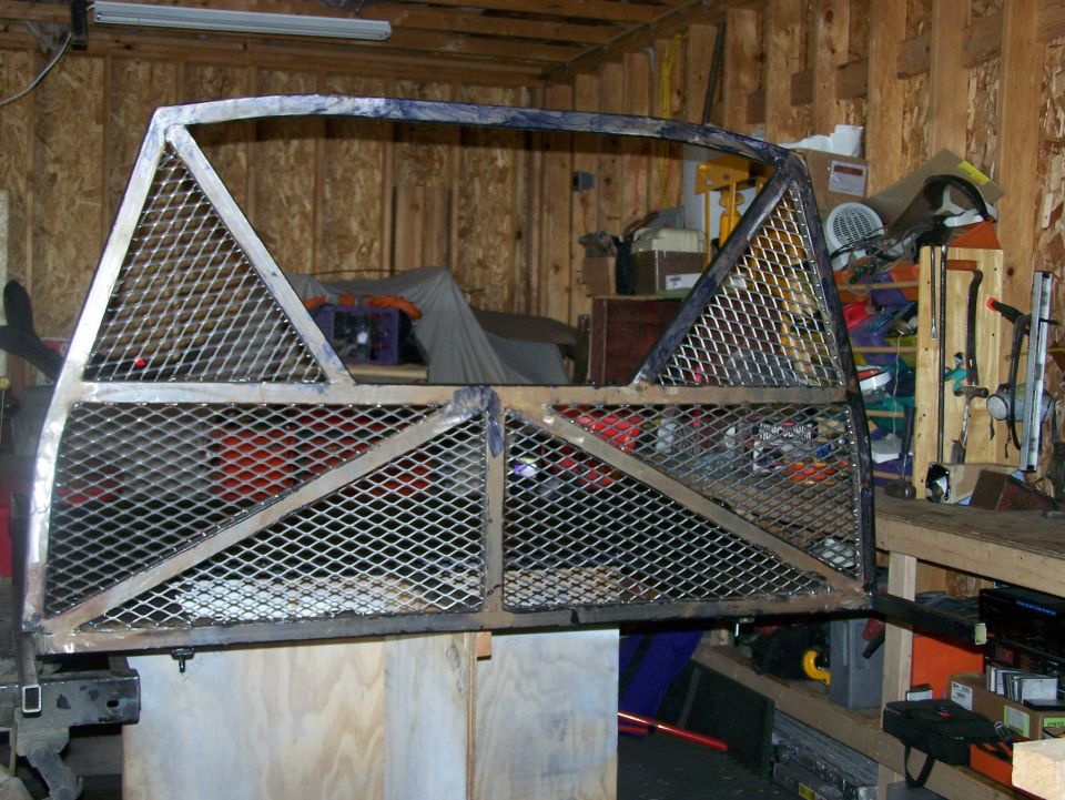 Custom metal cage frame with diamond plate mesh, possibly for a truck bed or off-road vehicle