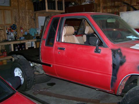 1988 Suzuki Samurai - This red flatbed truck is seen from the side, with its interior and chassis clearly visible.