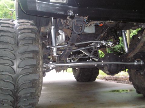 1978 Ford Bronco - Close-up view of the rear axle, suspension, and large tires on a modified vehicle.