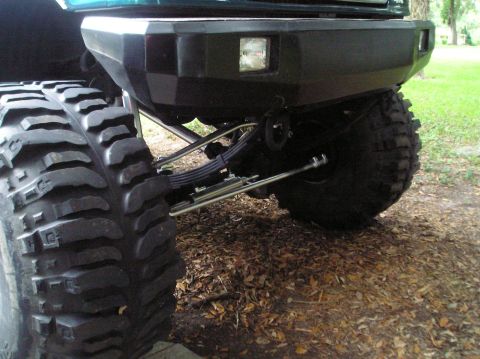 1978 Ford Bronco - Close-up of the rear suspension and tire of a modified SUV.