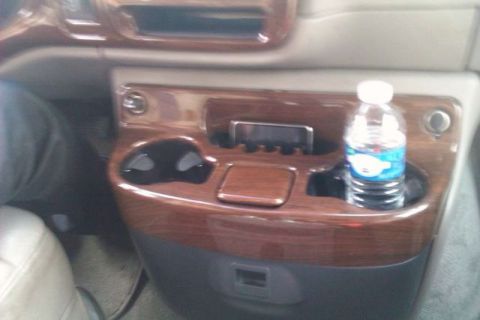 1991 Ford Crown Victoria - The interior console features wood grain trim, cup holders, and a bottle of water.