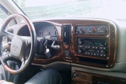1991 Ford Crown Victoria - Interior view of a van's dashboard, wood grain trim and the steering wheel.