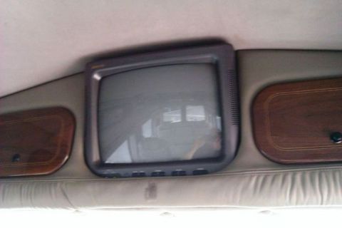 1991 Ford Crown Victoria - This photo shows the interior of a van, a television and storage compartments.
