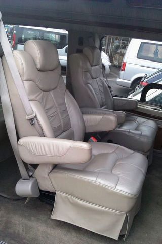 1991 Ford Crown Victoria - The interior of a van shows two plush captain's chairs, with other vehicles visible outside.