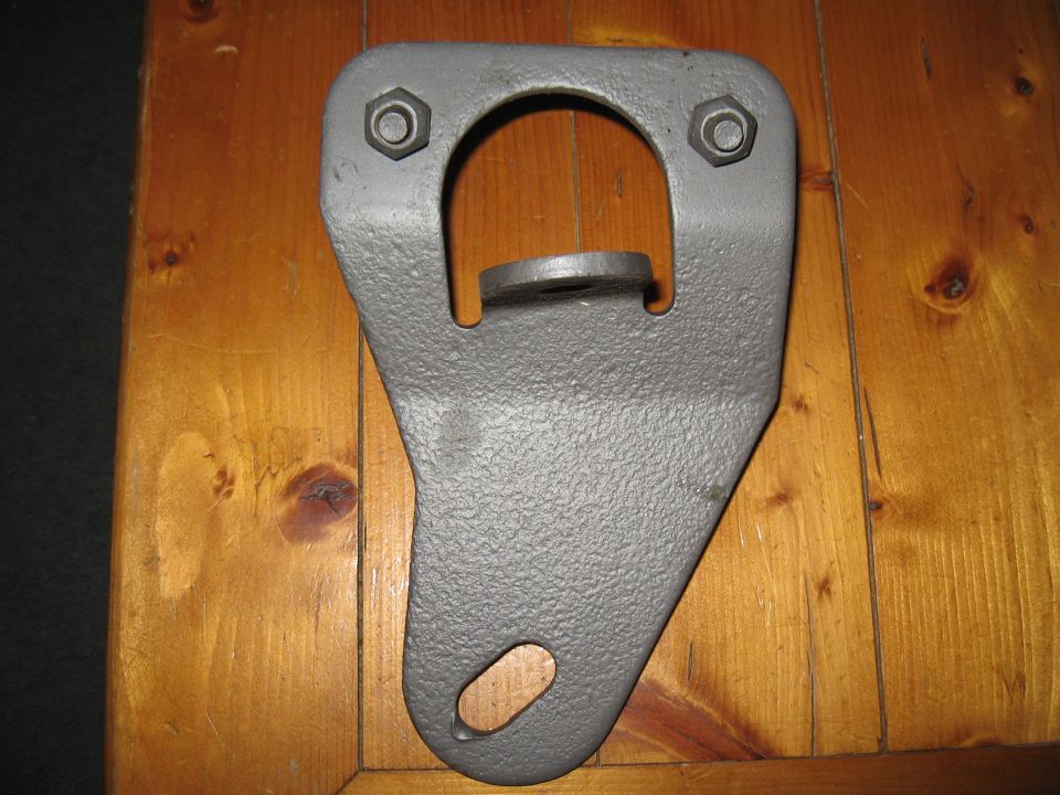 Gray metal tie down bracket with two bolts and an oval mounting hole