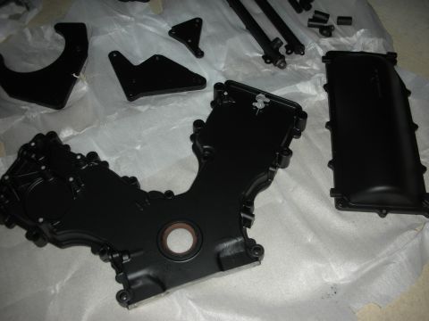 1992 Ford Crown Victoria - Various engine components, including a timing cover, are arranged on a surface covered with white paper.