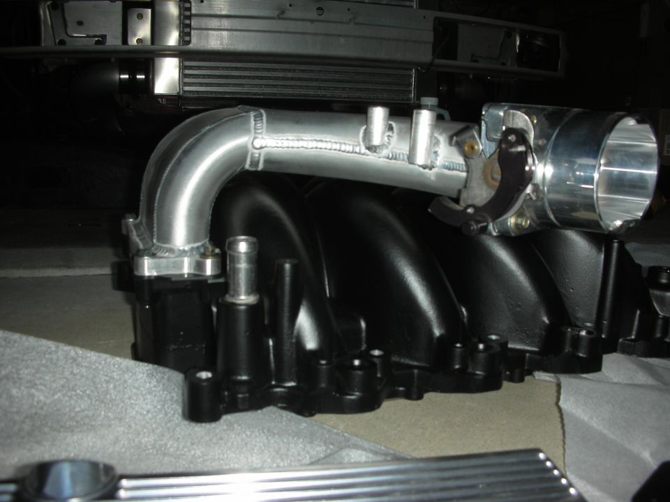 Aftermarket aluminum intake manifold with black runners and a silver throttle body