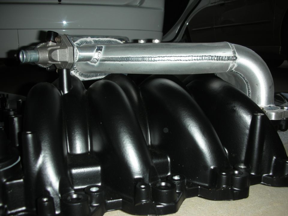 Aftermarket aluminum intake manifold with black runners and silver tubing