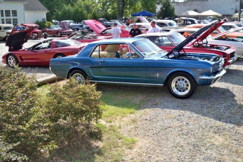1980 Ford Mustang - A blue classic Ford Mustang is parked at a car show with other vehicles present.