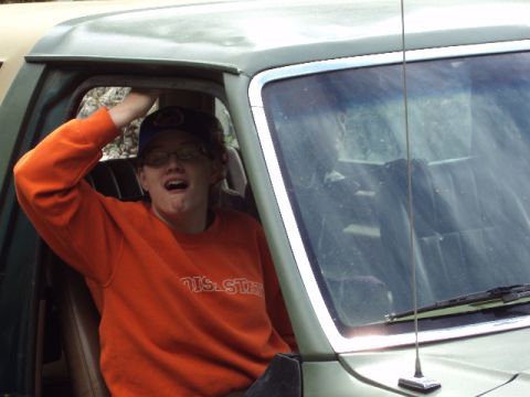 1989 Ford Bronco - A person with their arm raised is inside the driver's seat of a vehicle.