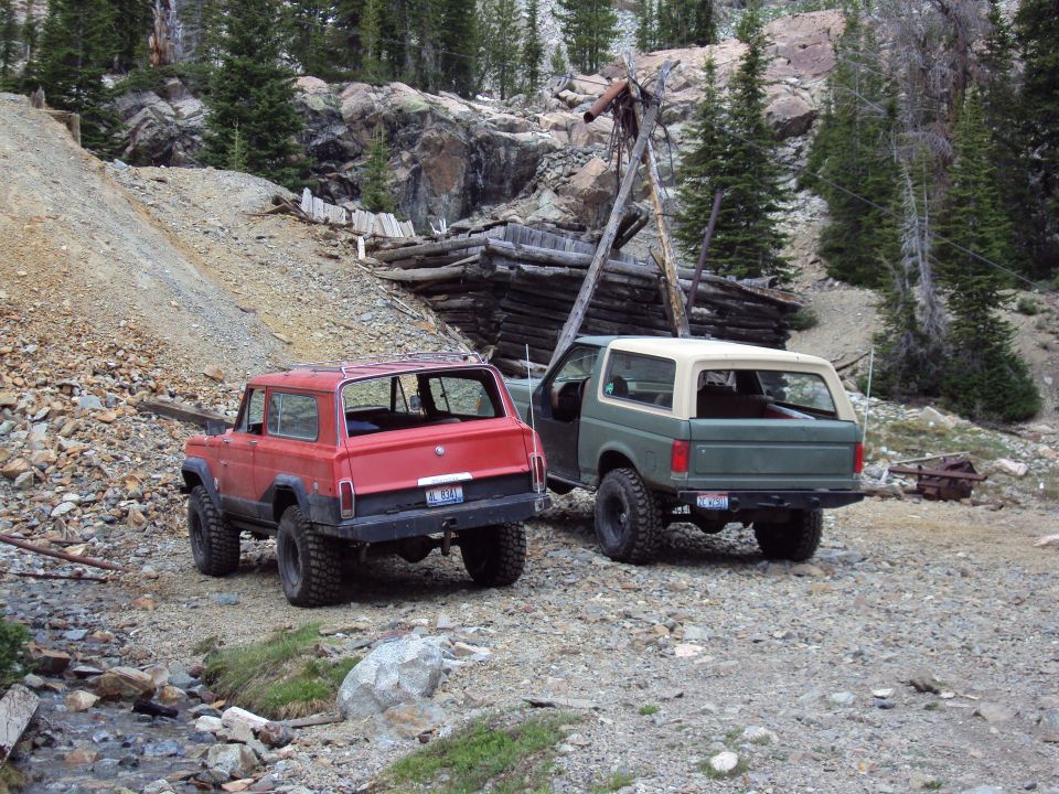 Green 1987 Ford Bronco and red Jeep Cherokee parked at abandoned mine