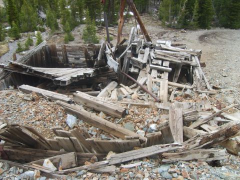 1989 Ford Bronco - Remains of an old wooden structure in a mountainous, wooded environment.