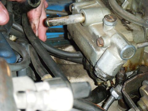 1985 Ford Bronco - Engine bay detail showing carburetor and various hoses, with a hand visible.